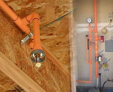 Orange fire sprinkler piping installation in a building ceiling and utility room